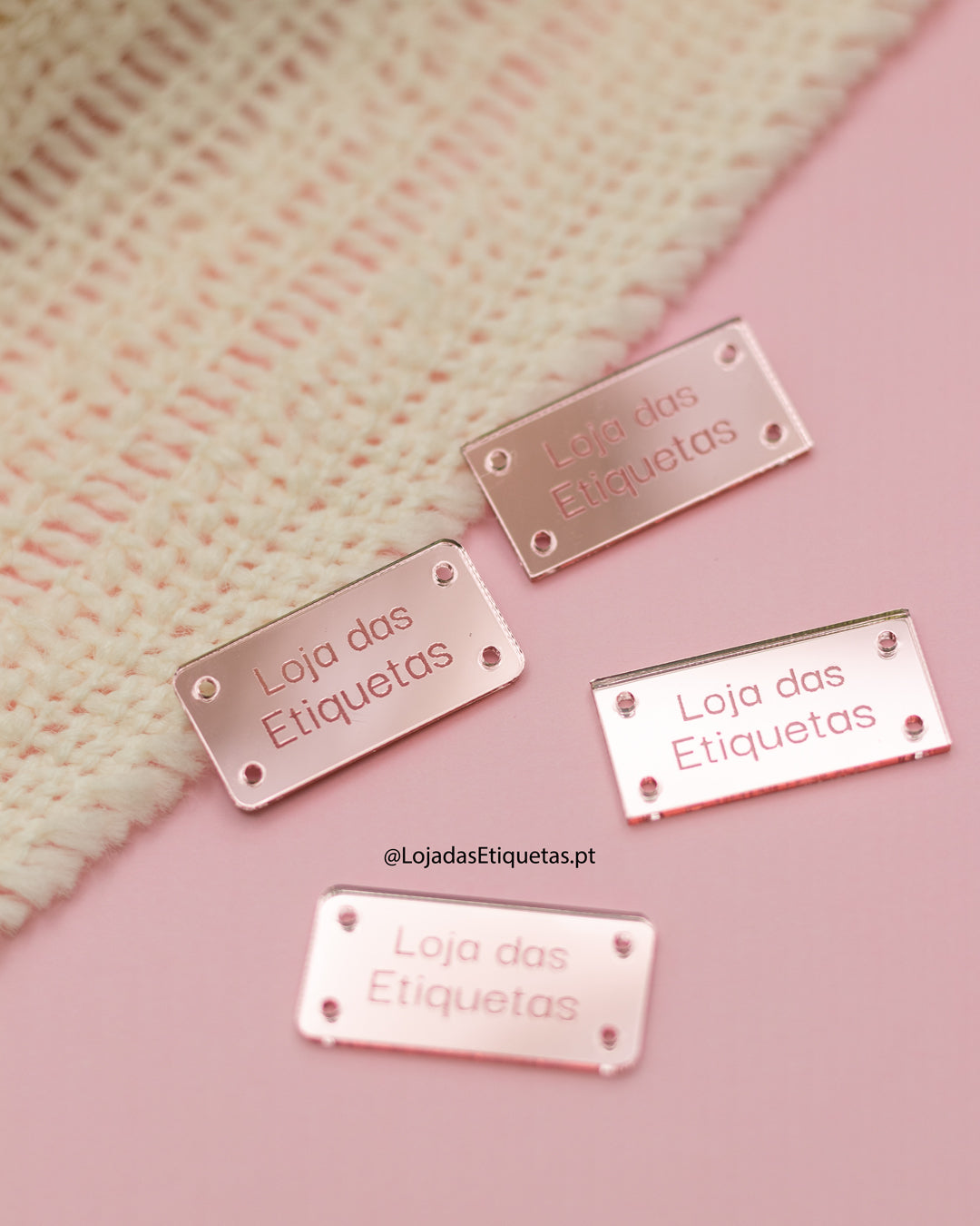 Etiqueta personalizada com logotipo em rosa claro espelhado. Etiquetas retangulares com cantos rectos e etiquetas com cantos arredondados. 4 furos para costura.