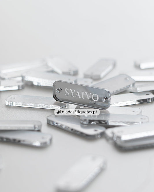 Etiqueta personalizada com logotipo em acrilico espelhado prateado com furos laterais.
