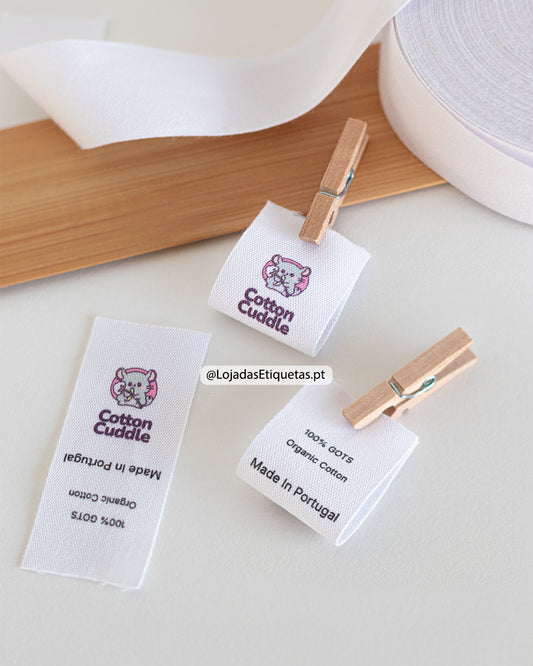 Etiqueta em algodão personalizada com logótipo a cores e informação da composição têxtil.