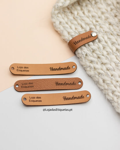 Etiquetas em napa dobráveis aplicadas com tachas