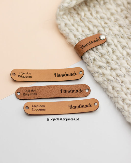 Etiquetas em napa dobráveis aplicadas com tachas